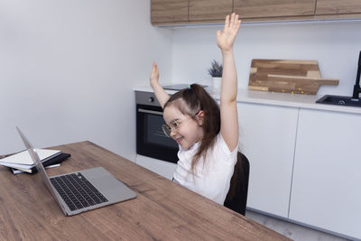 Rear view of woman using digital tablet while standing at home