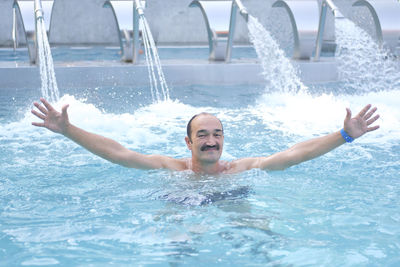 Man in thermal pool with hydromassage and  injectors with water jets
