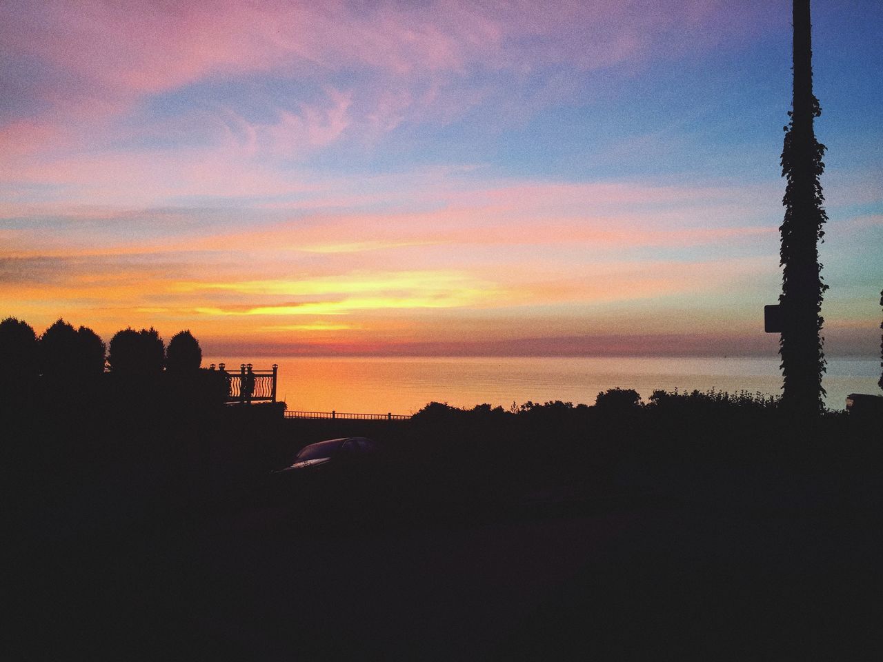 sunset, silhouette, sky, scenics, tranquil scene, beauty in nature, tranquility, orange color, sea, nature, water, idyllic, cloud - sky, dusk, dark, tree, built structure, outline, cloud, calm