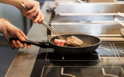 Midsection of man preparing food in kitchen