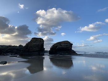 Rocks on sea shore against sky