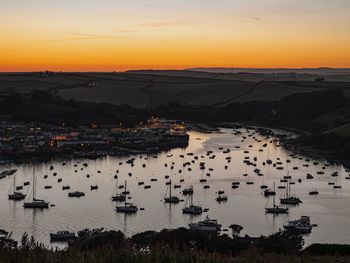 High angle view of sea by buildings against sky during sunset