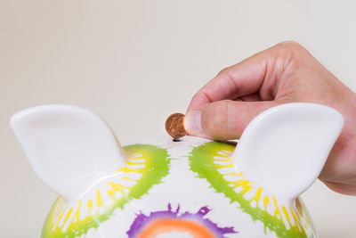 Close-up of hand holding food over white background