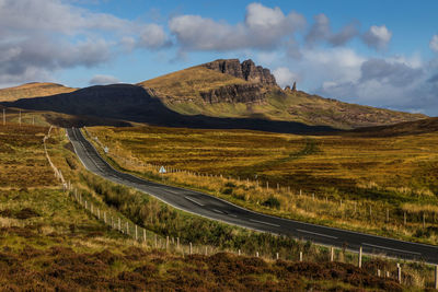 Scenic view of road by mountains against sky
