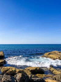 Scenic view of sea against clear blue sky