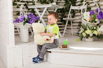 Full length of cute boy sitting on toy