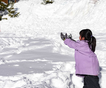 Woman photographing on snow covered land