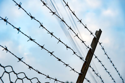 Low angle view of barbed wire against sky