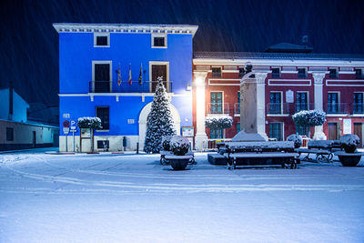 Illuminated buildings in city at night during winter