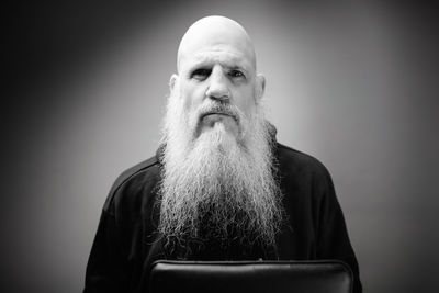 Portrait of man looking away against gray background