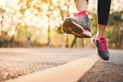 Low section of woman running on road