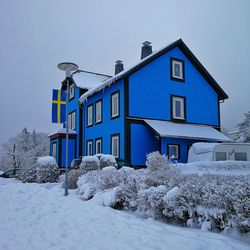 Built structure on snow covered land by building against sky