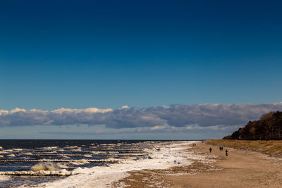 Scenic view of beach against blue sky