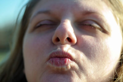 Close-up of woman puckering lips outdoors