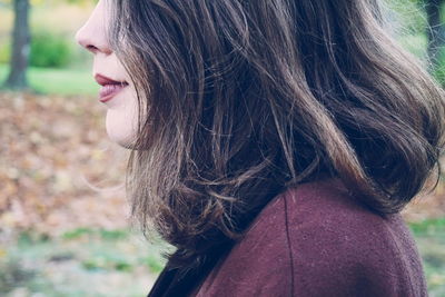 Profile view of young woman standing outdoors