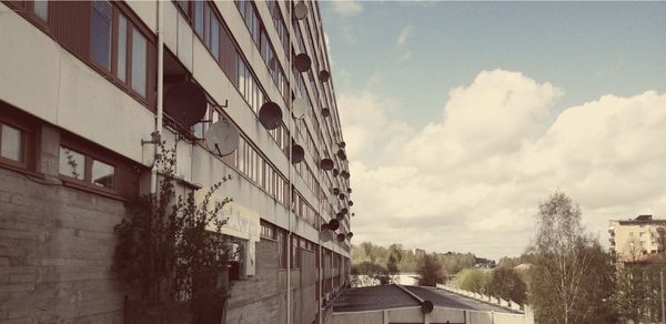 Buildings in city against cloudy sky