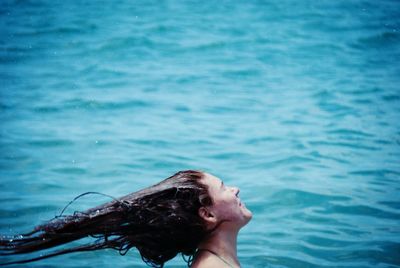 Woman with tousled hair against sea