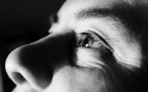 Close-up of human eye looking away against black background