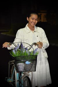 Portrait of smiling indonesian teenager holding bicycle