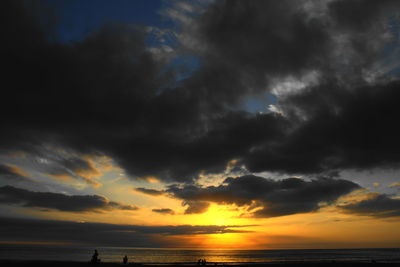 Scenic view of sea against dramatic sky during sunset