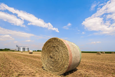 Hay bales on field against sky