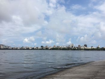 View of calm sea with cityscape in background