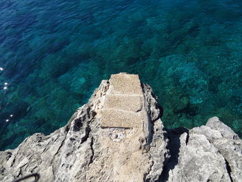 High angle view of rock by sea