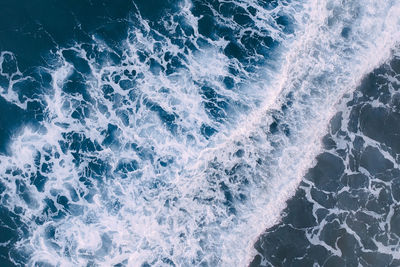 High angle view of wave splashing on rock