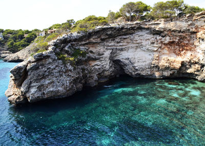 Rock formation in sea against sky