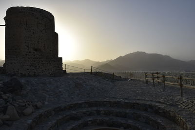 Stone wall against clear sky during sunset