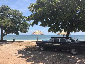 Car on beach against sky