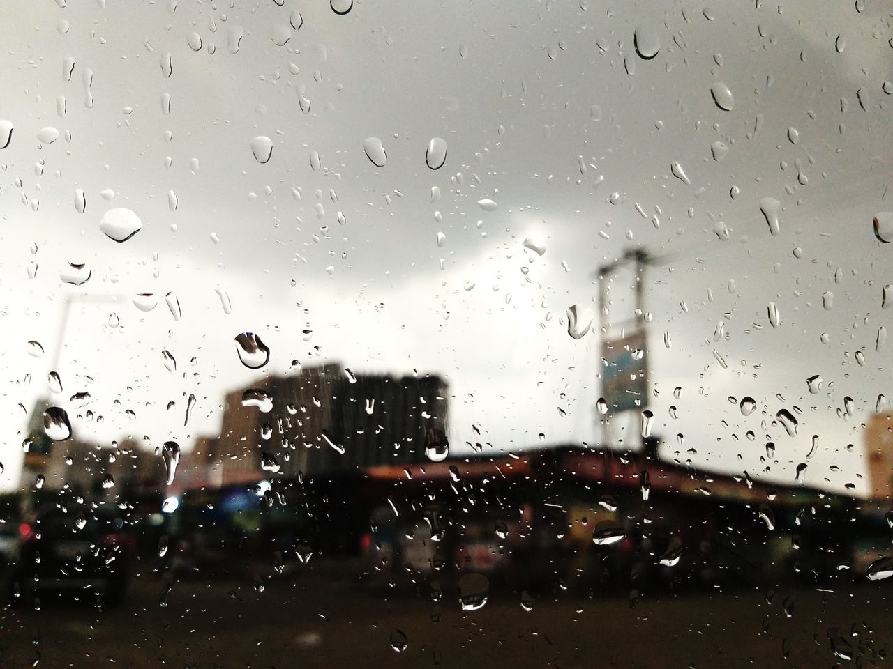 RAINDROPS ON GLASS WINDOW OF RAINY SEASON