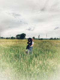 Woman standing on field against sky