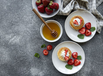 Cottage cheese pancakes, ricotta fritters on ceramic plate with fresh strawberry. 