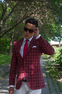 Young man wearing sunglasses standing against trees