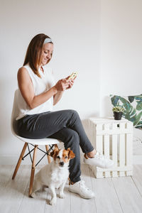 Full length of woman with dog standing on floor at home