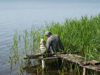 Father and child sitting on pier at beach