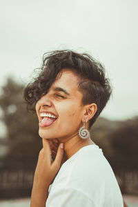 Portrait of a smiling young woman against sky