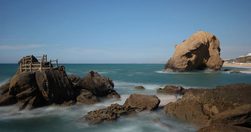 Scenic view of rock formation in ocean against sky