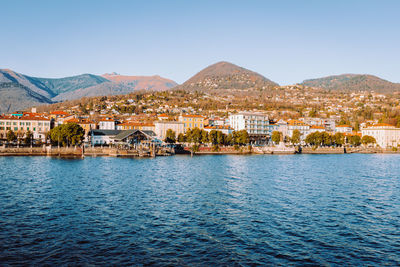 Scenic view of sea and mountains against clear blue sky