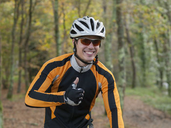 Portrait of smiling man riding bicycle at forest