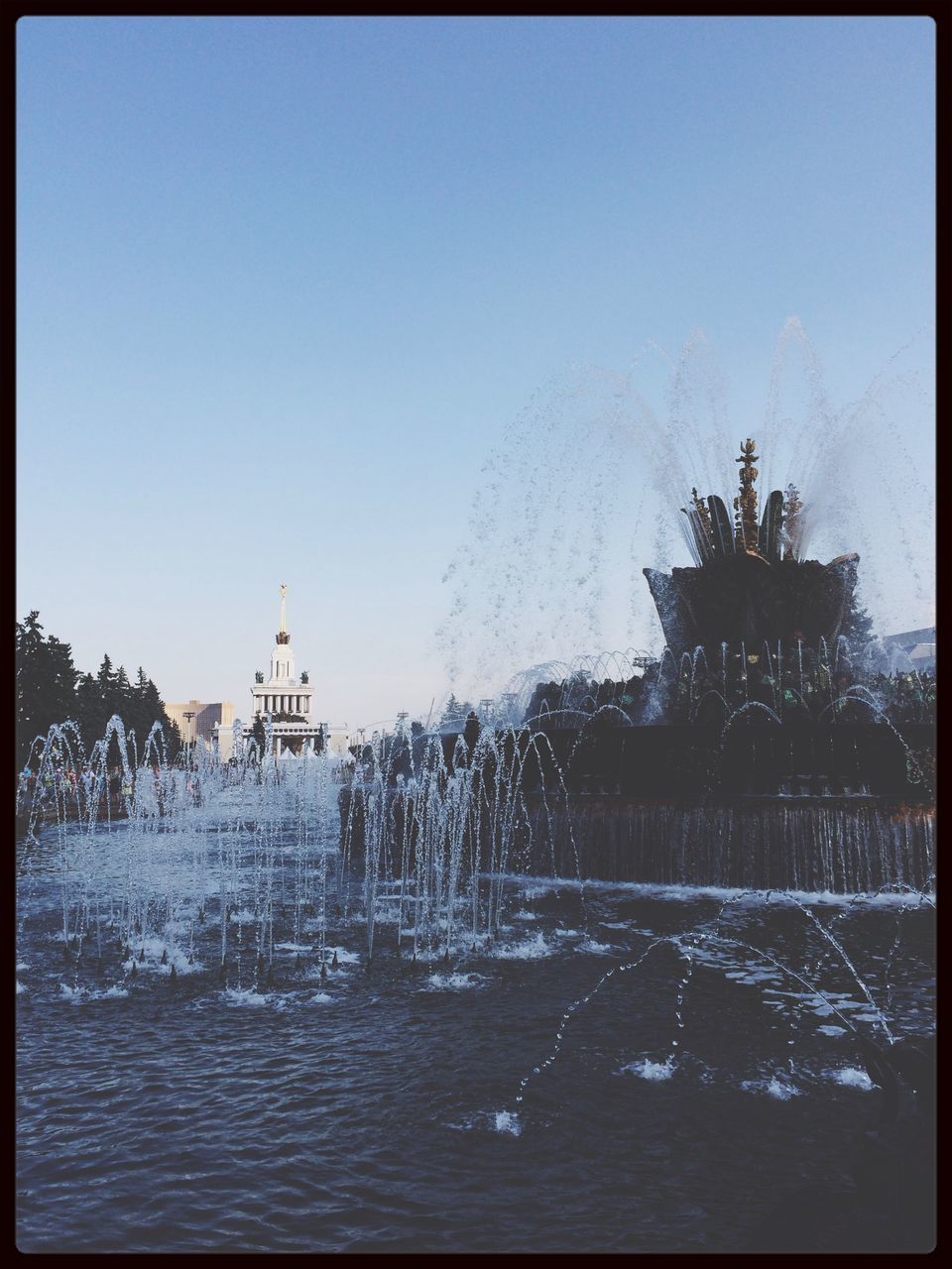 transfer print, clear sky, auto post production filter, water, winter, snow, cold temperature, tree, copy space, waterfront, season, nature, scenics, tranquility, beauty in nature, blue, tranquil scene, weather, built structure, fountain