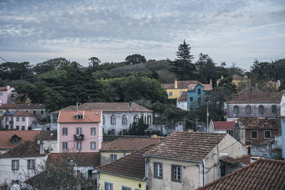 Colorful old apartment buildings on a hill with trees behind in sintra, portugal