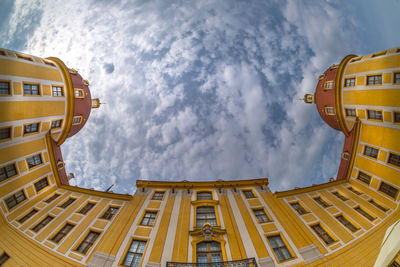 Low angle view of buildings against cloudy sky