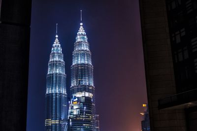 Low angle view of illuminated buildings against sky at night