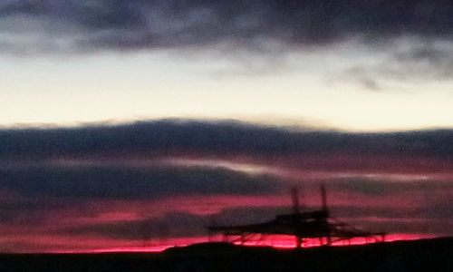 Silhouette landscape against sky at sunset