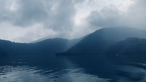 Scenic view of lake and mountains against sky