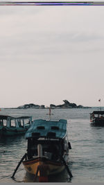 Boats moored in sea against sky