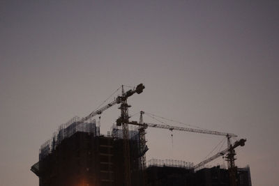 Low angle view of crane against clear sky