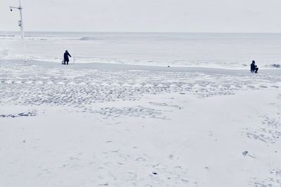 People enjoying at beach during winter